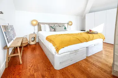 a bedroom with a white bed with a yellow blanket at Ria Formosa Vista Duplex Charm in downtown Faro in Faro