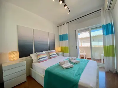 a bedroom with a bed with two towels on it at Quarteira Beach Apartment by Homing in Quarteira