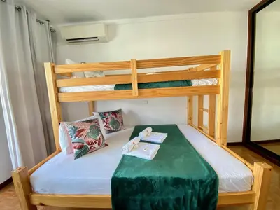 a bedroom with two bunk beds and a table at Quarteira Beach Apartment by Homing in Quarteira