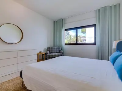 a bedroom with a bed and a mirror and a chair at AL - Apartamento Montemar in Vilamoura