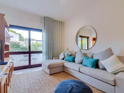a living room with a couch and a mirror at AL - Apartamento Montemar in Vilamoura