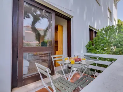 a table and chairs on a patio with a window at AL - Apartamento Montemar in Vilamoura