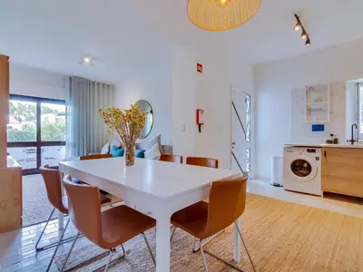 a kitchen and dining room with a white table and chairs at AL - Apartamento Montemar in Vilamoura