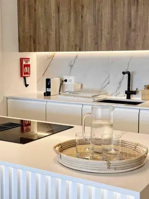 a kitchen with a glass pitcher on a tray on a counter at Front Sea Apartment Albufeira in Albufeira