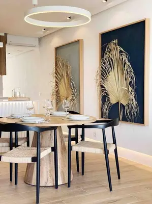 a dining room with two tables and chairs and paintings at Front Sea Apartment Albufeira in Albufeira