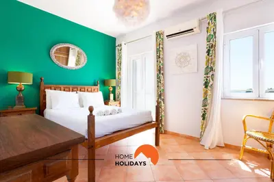 a green bedroom with a bed and a table at #185 V3 Laranjeiras by Home Holidays in Albufeira