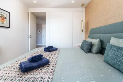 a bedroom with a bed with two blue pillows on it at Diamond Downtown Center in Faro