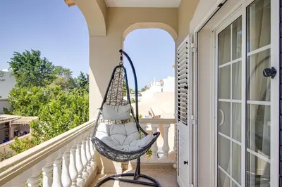 a porch with a hammock on a balcony at Private Deluxe 3BD Villa Pool Wi-Fi AC BBQ in Albufeira