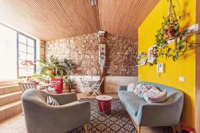 a living room with two chairs and a yellow wall at Sunlight House in Faro