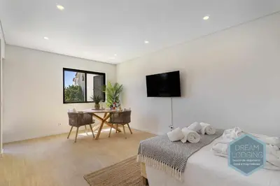 a bedroom with a bed and a table with a tv at Palm Tree - Dream Lodging in Albufeira