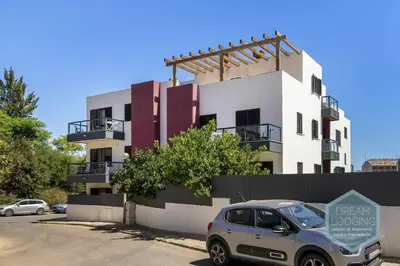 a car parked in a parking lot in front of a building at Palm Tree - Dream Lodging in Albufeira
