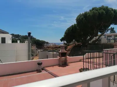 a balcony with a view of a tree and a fence at EMCA HOME Albufeira in Olhos de Água