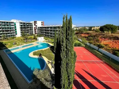 an overhead view of a pool with a tennis court and trees at Residence Golf-Vilamoura! in Quarteira