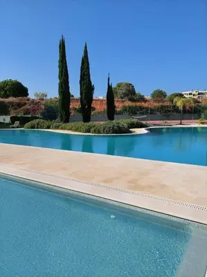 a large swimming pool with trees in the background at Residence Golf-Vilamoura! in Quarteira