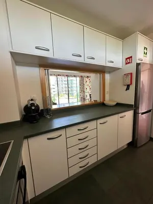 a kitchen with white cabinets and a refrigerator at Residence Golf-Vilamoura! in Quarteira