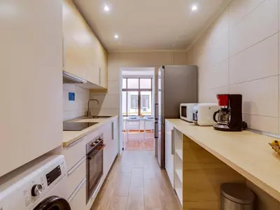 a kitchen with white cabinets and a counter top at AL - Apartamento Moural in Quarteira