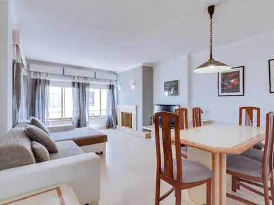 a living room with a table and a couch at AL - Apartamento Moural in Quarteira