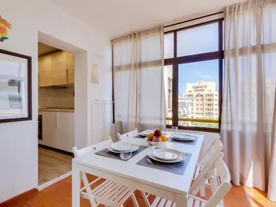 a white dining room with a white table and chairs at AL - Apartamento Moural in Quarteira