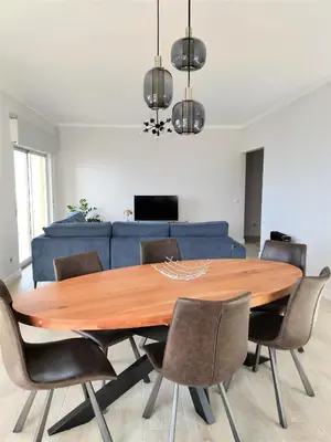 a dining room table with chairs and a blue couch at T2 Requinte e Vista Mar 4 pax in Quarteira