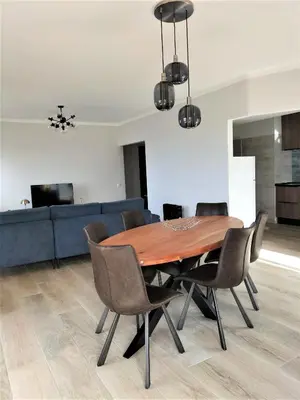 a dining room with a wooden table and chairs at T2 Requinte e Vista Mar 4 pax in Quarteira