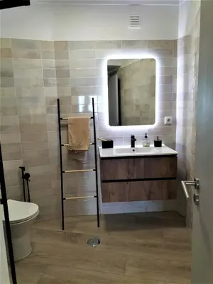 a bathroom with a sink and a toilet and a mirror at T2 Requinte e Vista Mar 4 pax in Quarteira