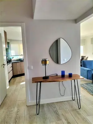 a table with a lamp and a mirror on a wall at T2 Requinte e Vista Mar 4 pax in Quarteira