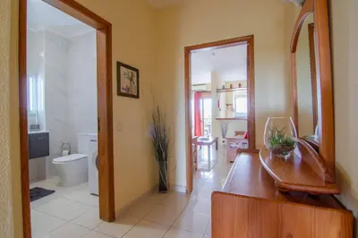 a bathroom with a sink and a mirror and a toilet at Apartamento Turistico Silva in Albufeira