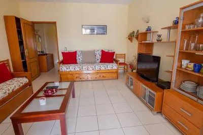 a living room with a couch and a tv at Apartamento Turistico Silva in Albufeira