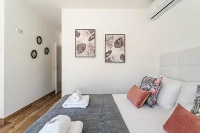 a white room with a bed and four pictures on the wall at Privilege Casa dos Capuchinhos, in the heart of Faro in Faro