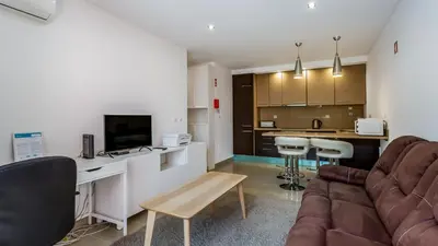 a living room with a couch and a kitchen at Luminous 2 BDR Apartment W/Pool by LovelyStay in Albufeira