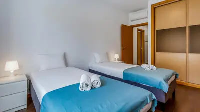 two beds in a hotel room with towels on them at Luminous 2 BDR Apartment W/Pool by LovelyStay in Albufeira