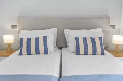 a bedroom with two beds with pillows and two lamps at Terracos de Quarteira II Navy by Real Properties in Quarteira