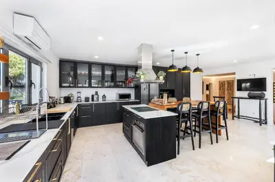 a kitchen with black cabinets and a table with chairs at Casa Chameleon in Almancil