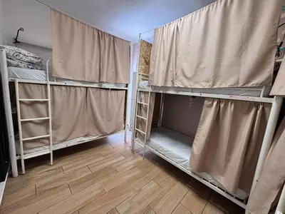 a room with bunk beds with curtains and a wooden floor at Orange Terrace Hostel in Albufeira