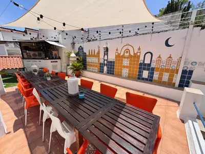 a living room with green couches and a table at Orange Terrace Hostel in Albufeira
