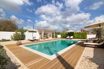 a pool with a wooden deck next to a house at Casa de Benafim 1 in Benafim