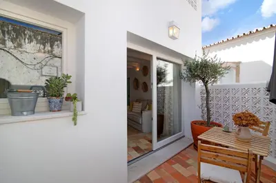 a white house with a table and a window at Casa de Benafim 51 in Benafim