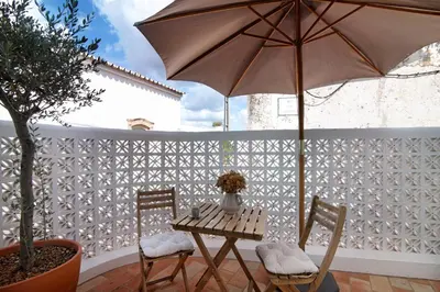 a table and chairs with an umbrella on a patio at Casa de Benafim 51 in Benafim