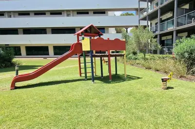 a playground with a slide in the grass at Spacious Residence Golf apartment - Vilamoura in Quarteira