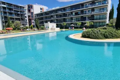 a large swimming pool in front of a building at Spacious Residence Golf apartment - Vilamoura in Quarteira