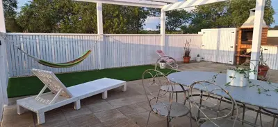 a patio with a hammock and a table and chairs at Solar da Cotovia in Albufeira