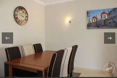 a dining room with a table and a clock on the wall at Casa Mar à Vista in Cavacos