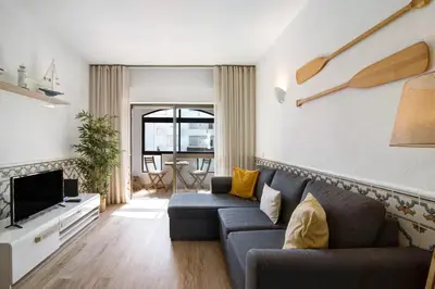 a living room with a couch and a tv at Blue wave escape apartment -T1 perto da praia com varanda in Albufeira