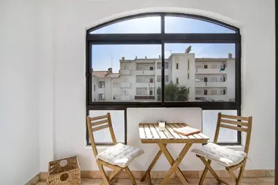 a table and two chairs in front of a window at Blue wave escape apartment -T1 perto da praia com varanda in Albufeira
