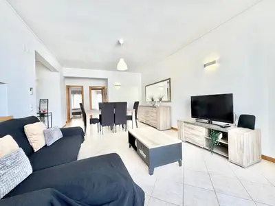 a living room with a couch and a tv and a table at Sea-Front 1' Min! - Apartment with AC & WiFi in Quarteira