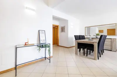 a dining room with a table and black chairs at Sea-Front 1' Min! - Apartment with AC & WiFi in Quarteira