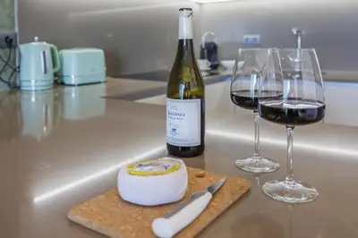 a bottle of wine and two wine glasses on a counter at Terracos de Quarteira II Yellow by Real Properties in Quarteira