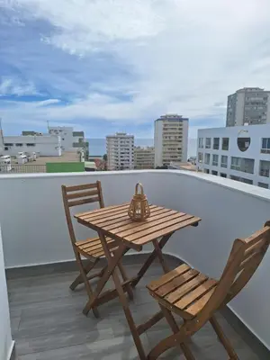 a wooden table and two chairs on a balcony at Cool living Quarteira, 2 bedroom with ocean view in Quarteira