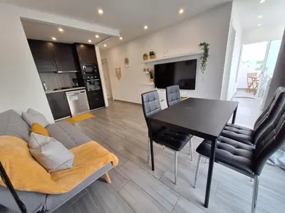 a living room with a couch and a table and chairs at Cool living Quarteira, 2 bedroom with ocean view in Quarteira