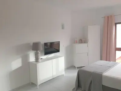 a white room with a television and a bed at CASA Vila Magna T0 in Albufeira